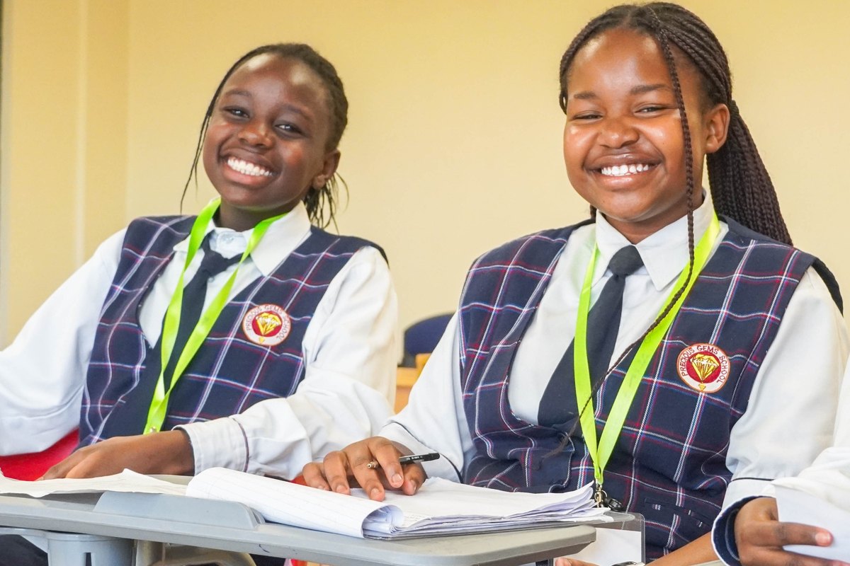 Two students smiling with open notebooks at a Lexicon event