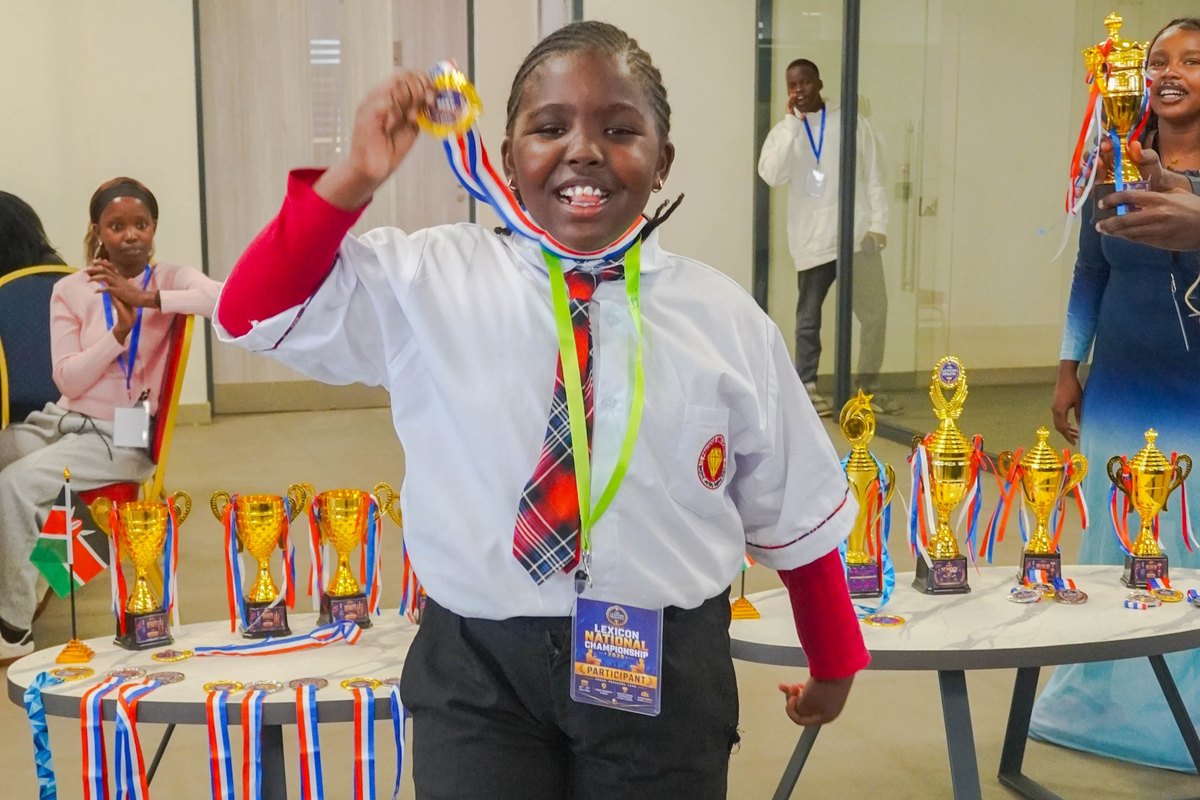 Student celebrating with a medal beside the awards table